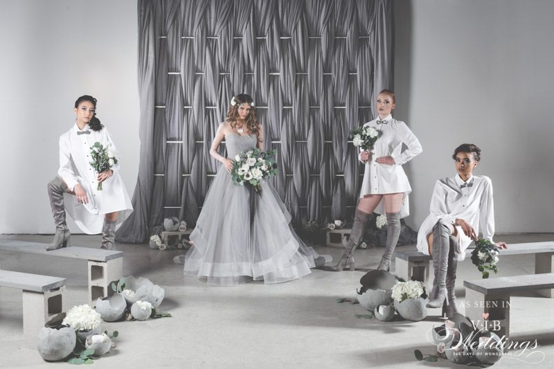 A group of women are standing next to each other in a room holding bouquets of flowers.