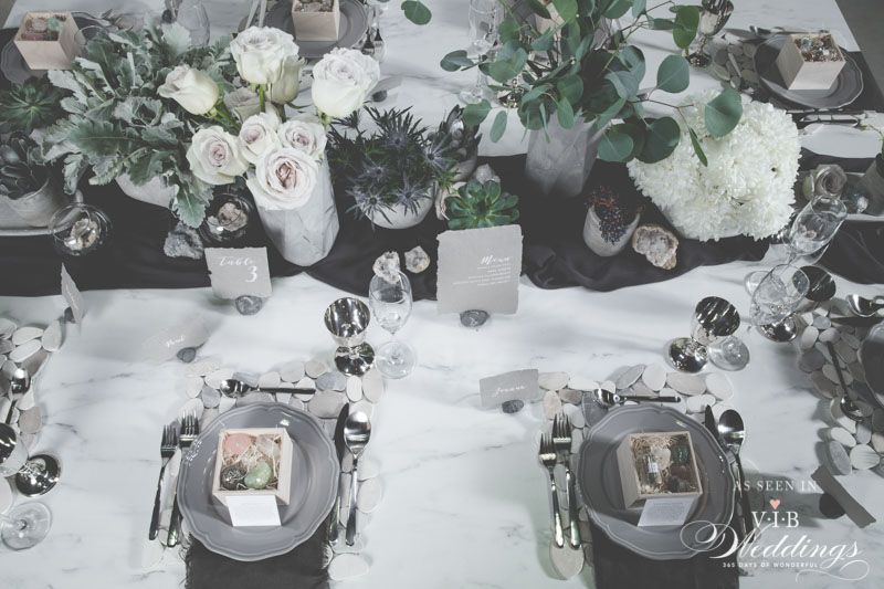 A table with plates , silverware , and flowers on it.