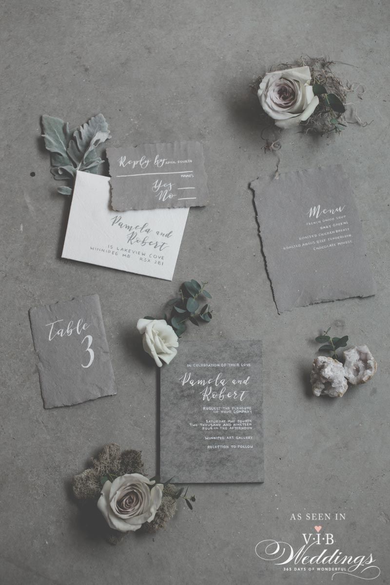A set of wedding invitations and flowers on a table.