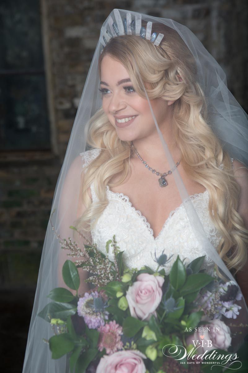 The bride is wearing a veil and holding a bouquet of flowers.