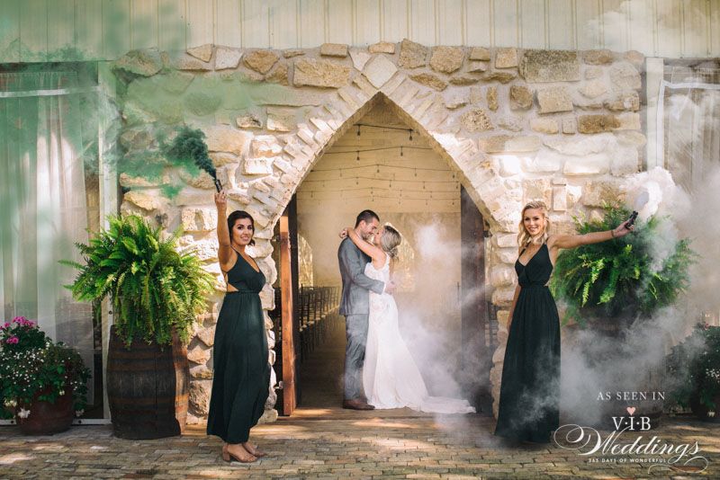 A bride and groom are posing for a picture with their bridesmaids.
