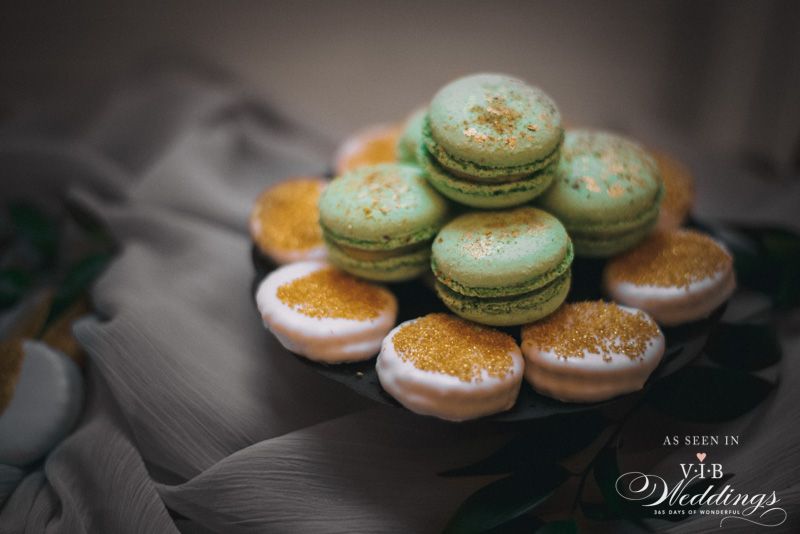 A plate of macarons and cookies on a table.