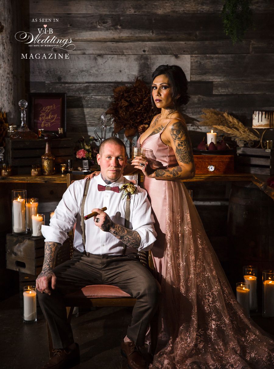 A bride and groom are posing for a picture in a room with candles.