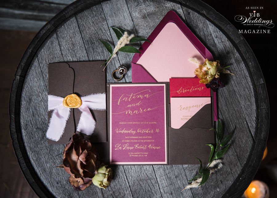 A wedding invitation is sitting on top of a wooden barrel.