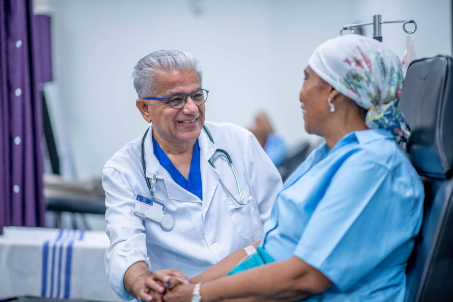 Doctor smiling and talking with a patient in a hospital setting