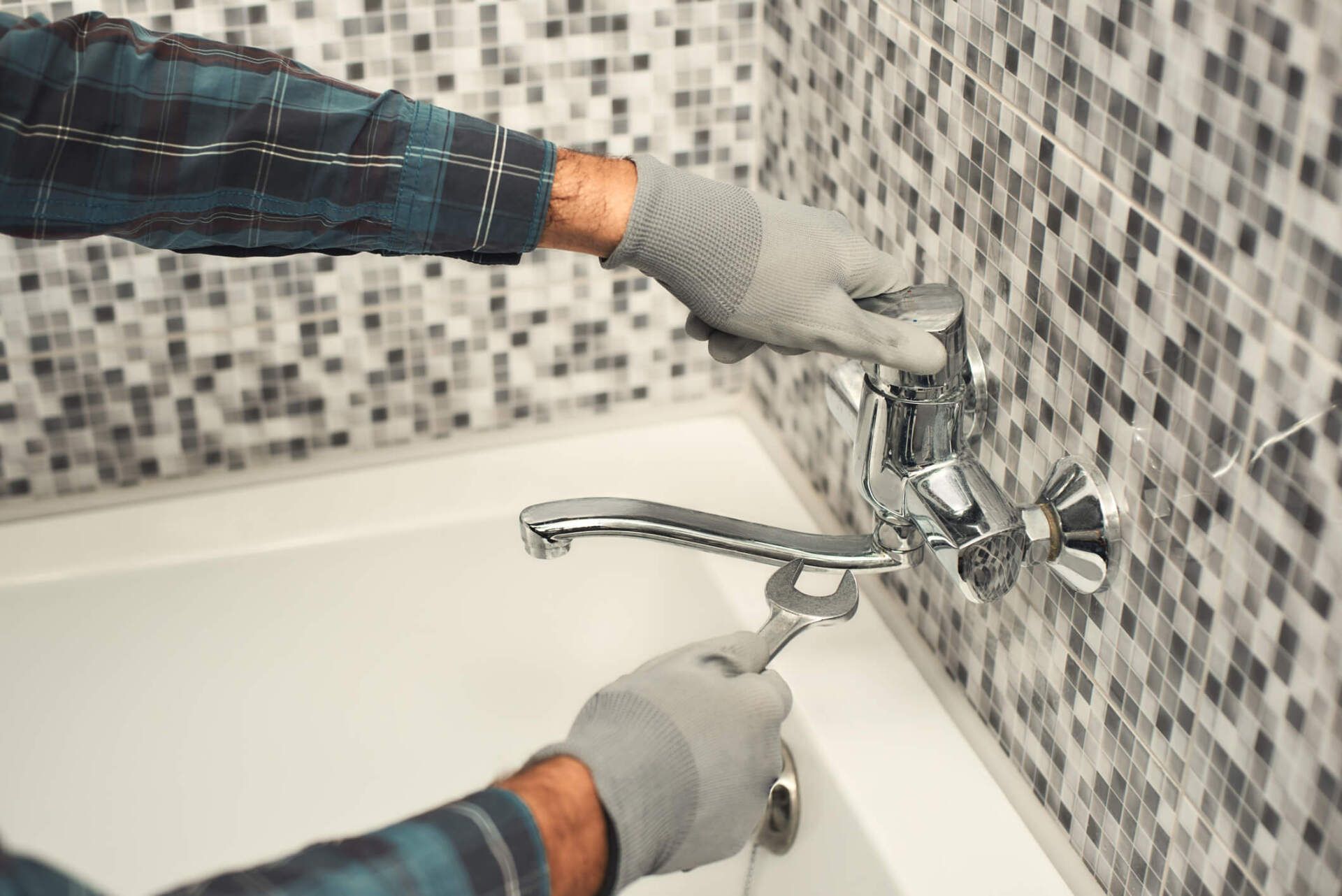 Plumber Repairing a Tap in the Bathroom — Rockford, IL — ProTech Plumbing Heating & Cooling Plumber Repairing a Tap in the Bathroom — Rockford, IL — ProTech Plumbing Heating & Cooling