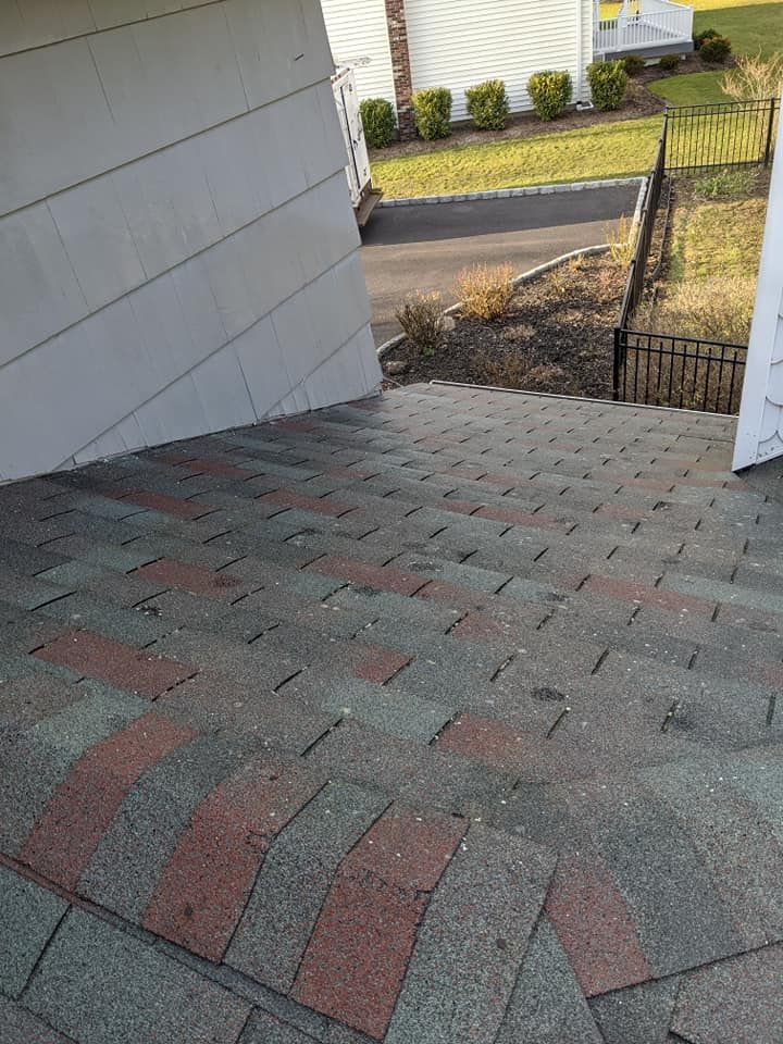 A staircase leading up to a house with a roof that is missing shingles.