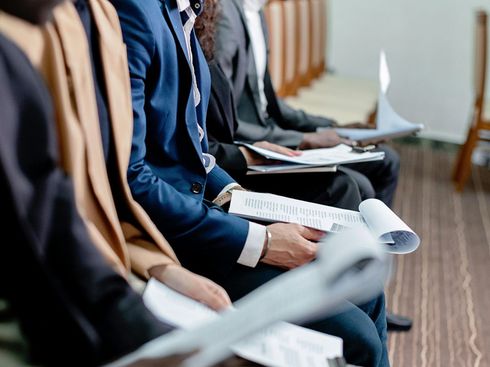 A group of people are sitting in a row at a job interview.