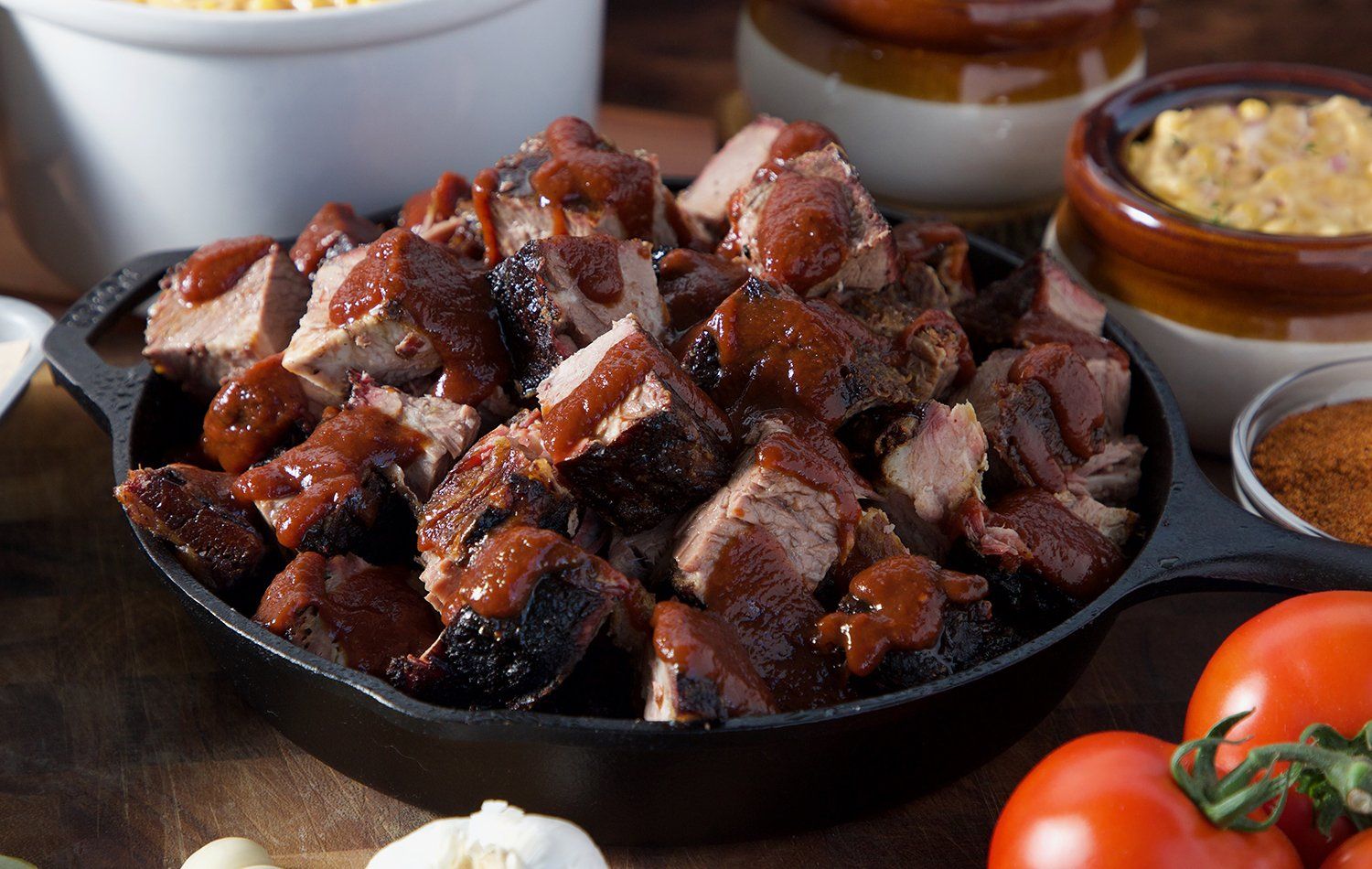 Skillet filled with meat and tomatoes in Gladstone Smokehouse BBQ