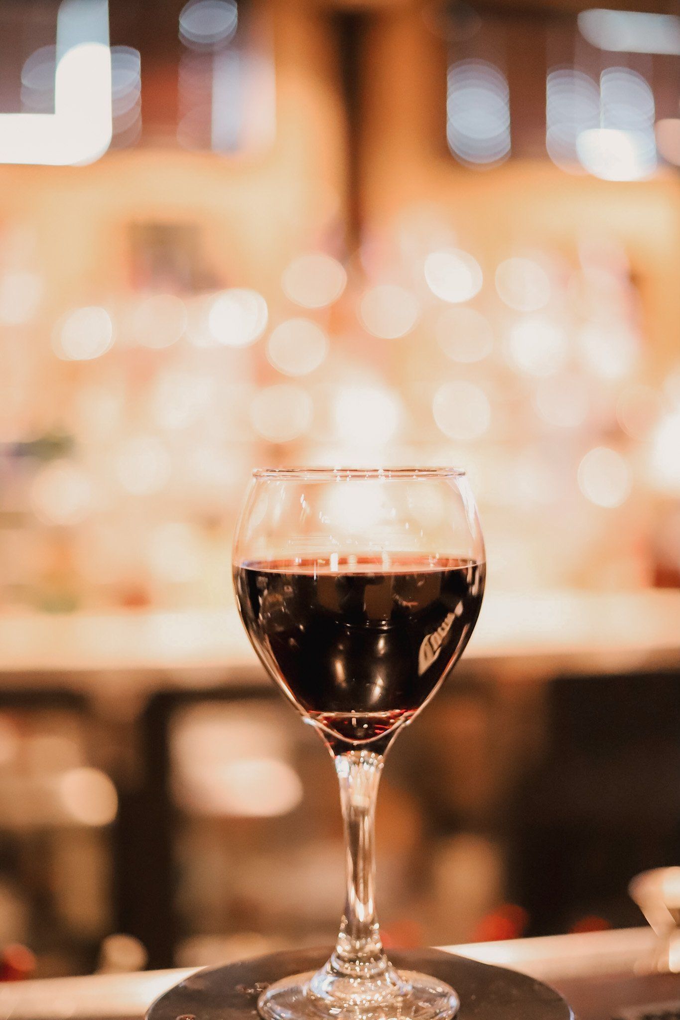 Half-filled glass of wine with wine being poured into it