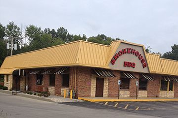 A brick building with a yellow roof and the word brokenhouse on it.