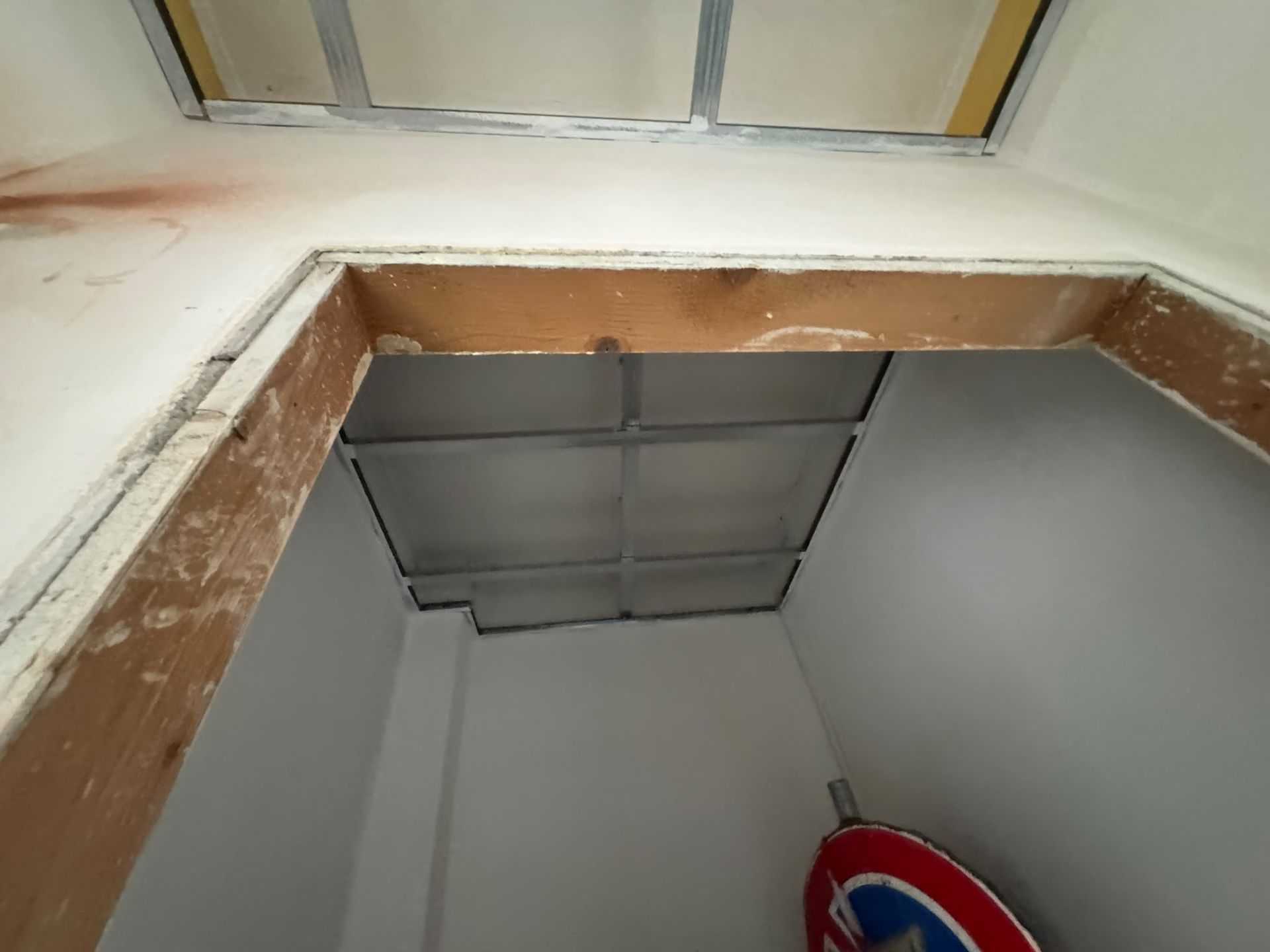 Botola della soffitta aperta con una scala visibile in un soffitto bianco.
