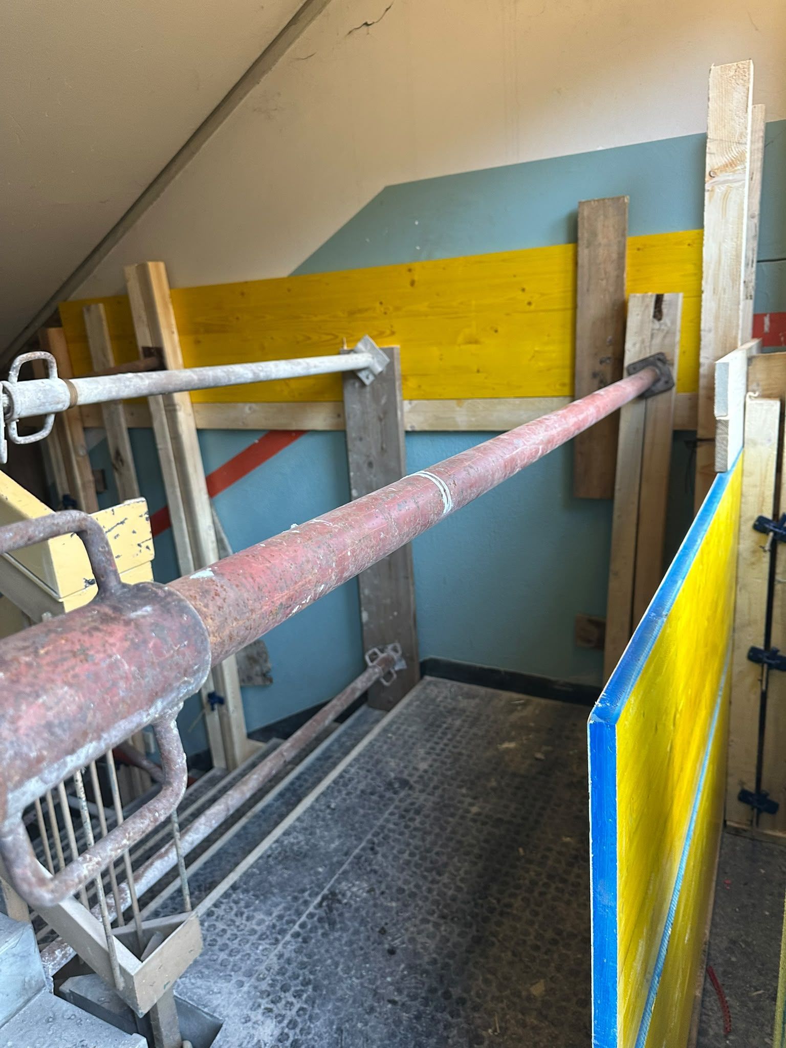 Vano scale interno con barriere di sicurezza, grigliato metallico e pareti dipinte a colori vivaci