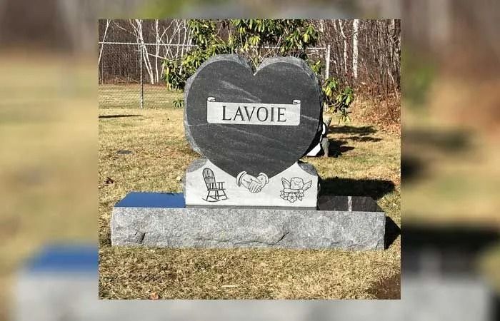 Heart-shaped black-and-white gravestone engraved “LAVOIE” in a grassy cemetery.