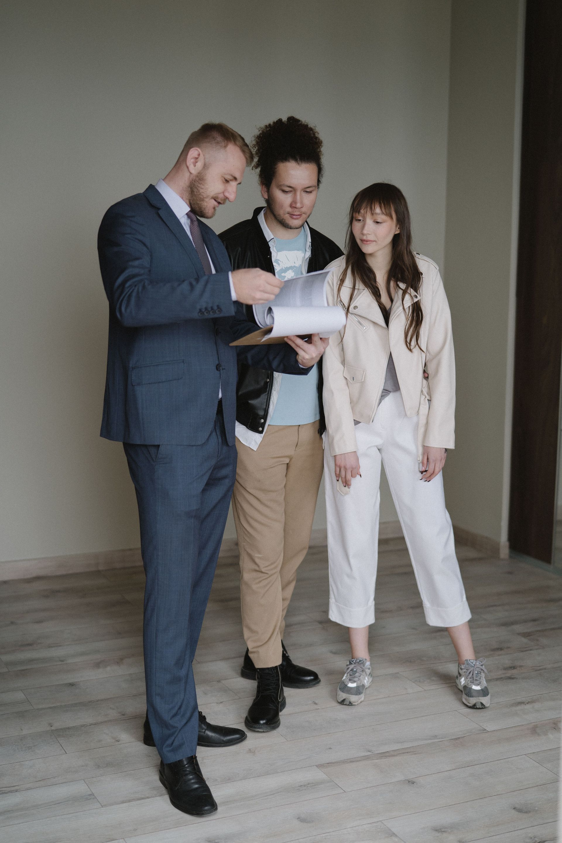 Three professionals reviewing papers together in a bare room