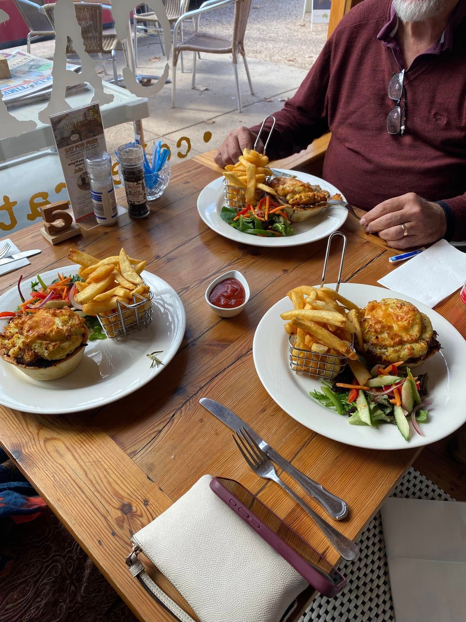 Three Plates of Food on a Table at a Cafe, With a Person Reaching for Their Meal — 321 Cafe Learmonth In Learmonth, VIC