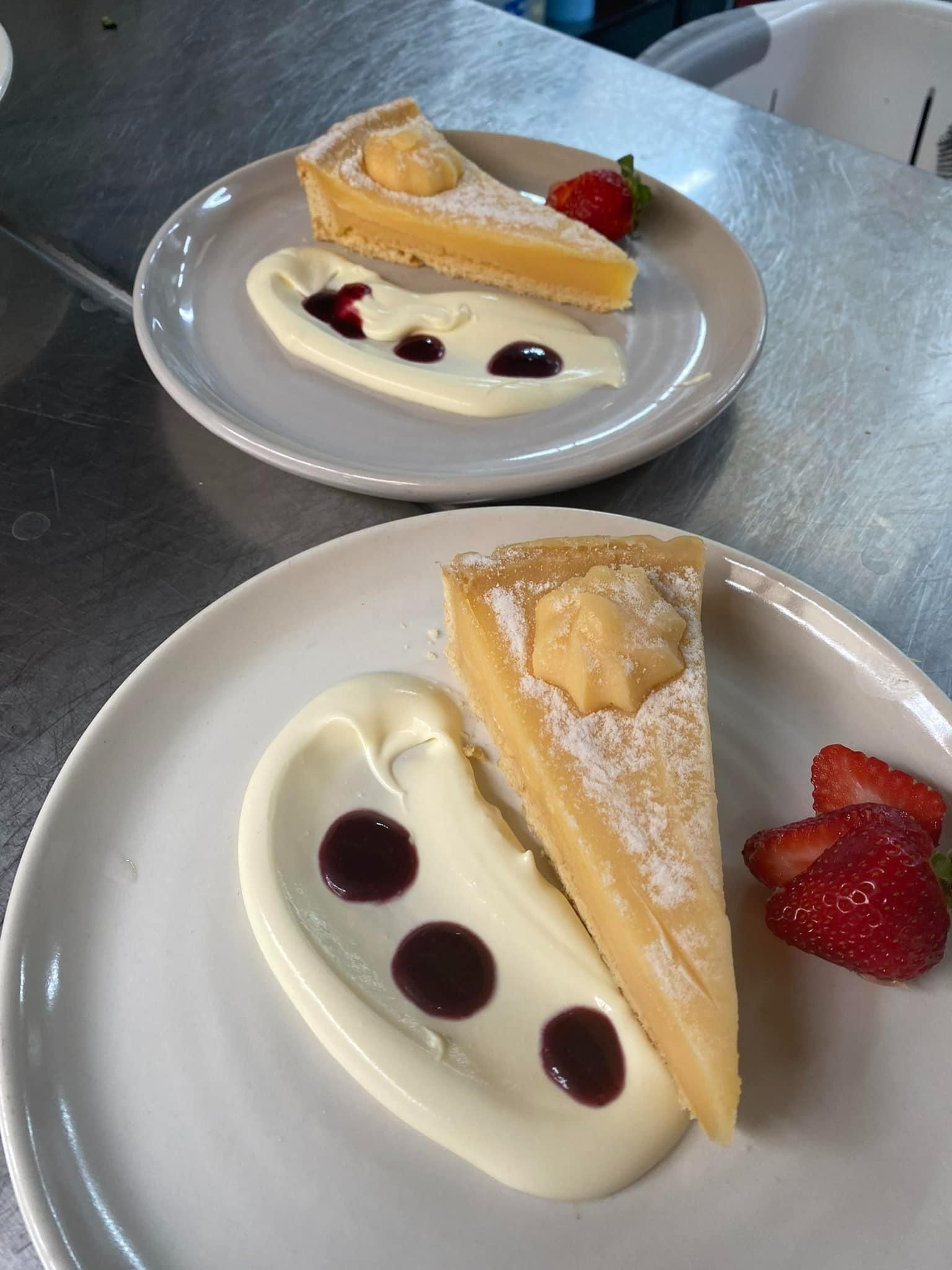 Two Plates With Lemon Tarts, Cream Sauce, Strawberry Slices, and Dark Sauce Dots — 321 Cafe Learmonth In Learmonth, VIC