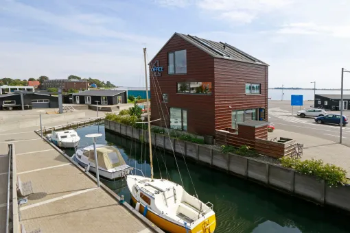 En båd ligger foran en bygning ved siden af en kanal