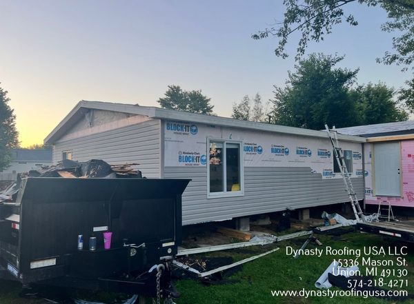 House under construction with siding, wrap, and window installation.