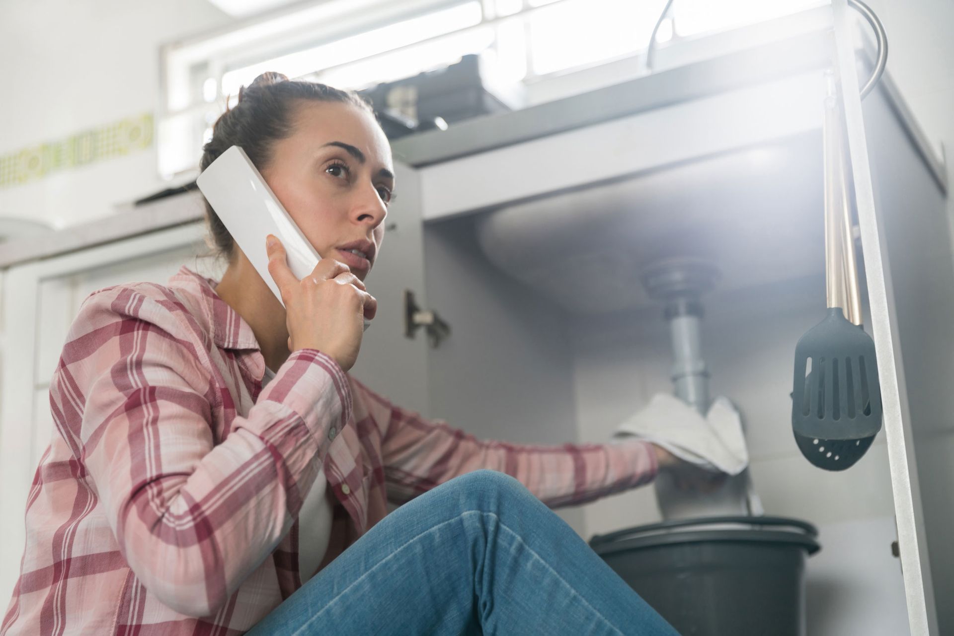 Woman Calling Plumber — Norwood, MA — Norfolk County Plumbing & Heating