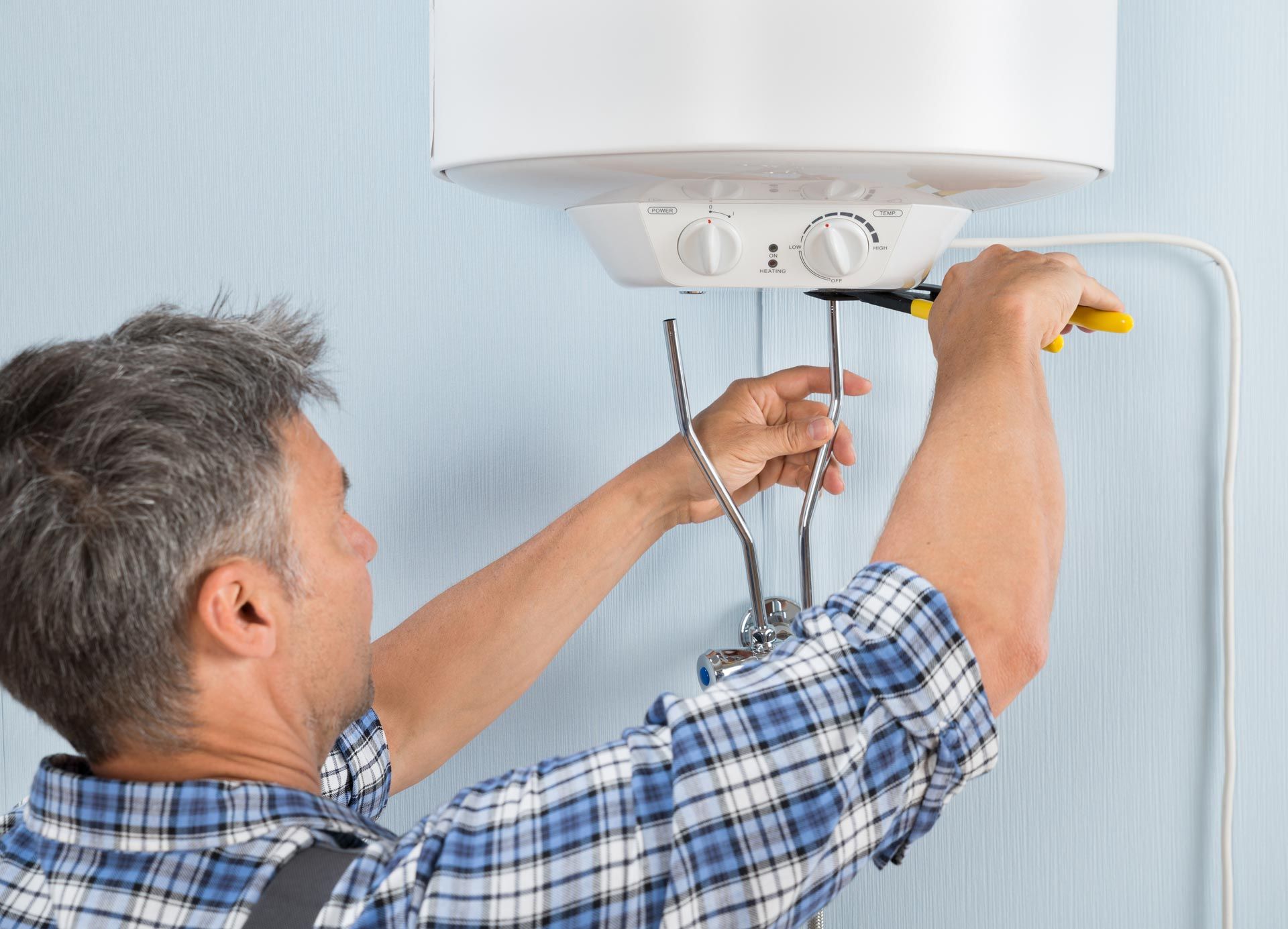 Installing Water Heater — Norwood, MA — Norfolk County Plumbing & Heating Installing Water Heater — Norwood, MA — Norfolk County Plumbing & Heating