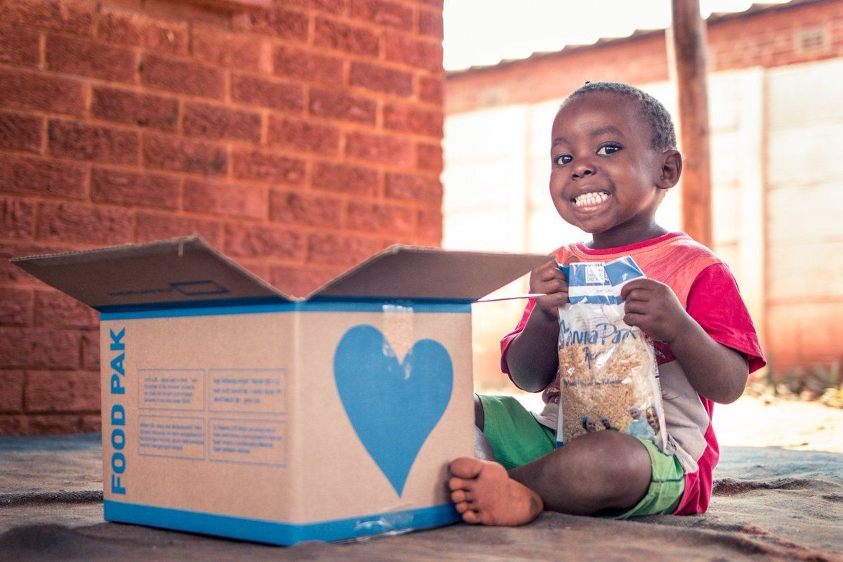 little boy holding food from donated food pak