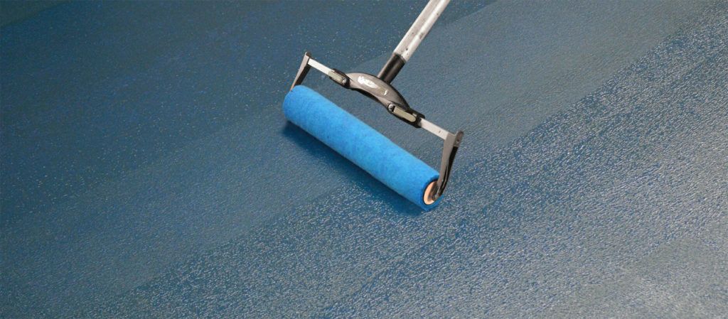 A blue roller is being used to paint a blue surface.