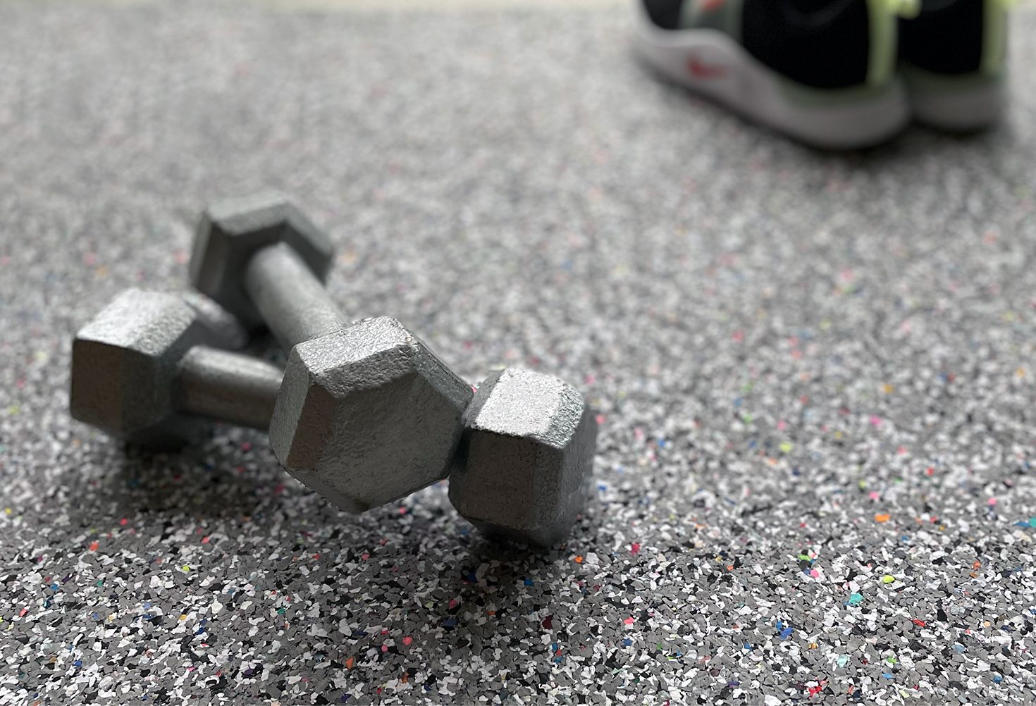 A pair of dumbbells sitting on top of a gym floor.