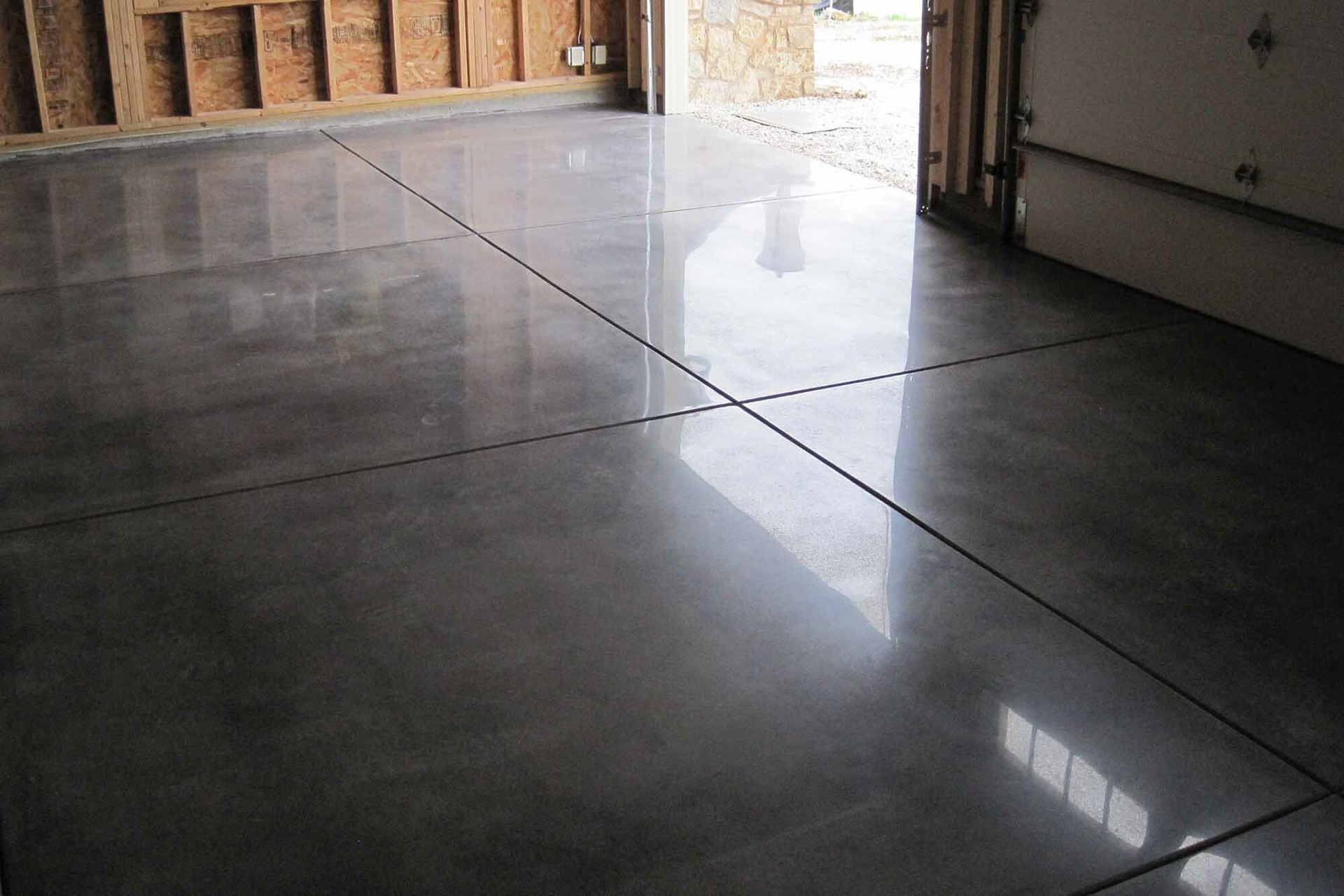 A shiny concrete floor in a garage next to a garage door