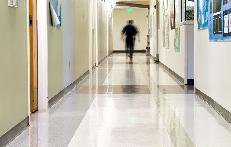 A blurry picture of a man walking down a hospital hallway.