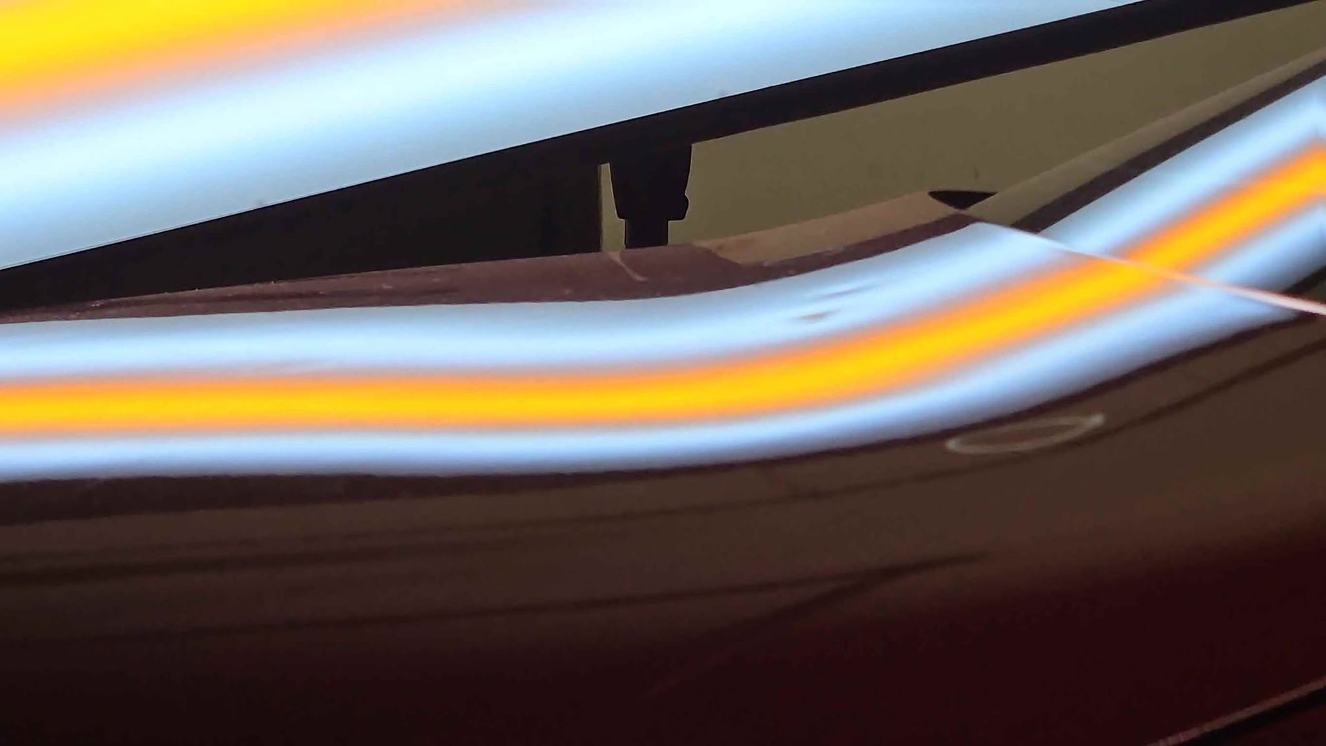 Abstract streaks of blue, white, and orange light over a dark surface