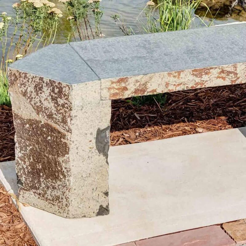 Stone memorial bench by walkway