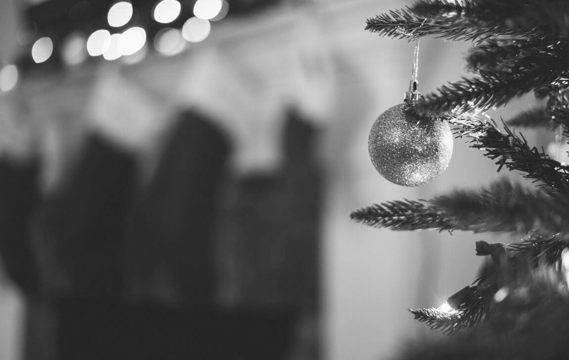 A solitary Christmas bauble hangs in front of a heavily blurred background of stockings, representing the
loneliness of grief during the holidays