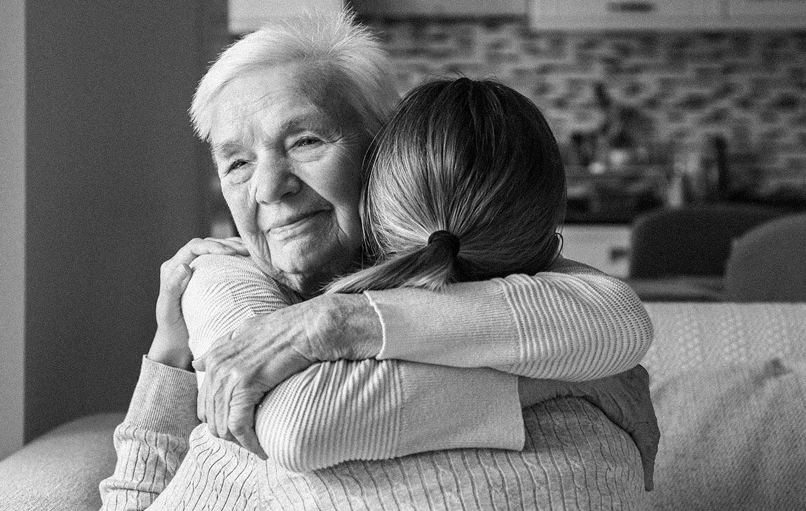 Older woman hugging younger woman to comfort her as she is grieving
