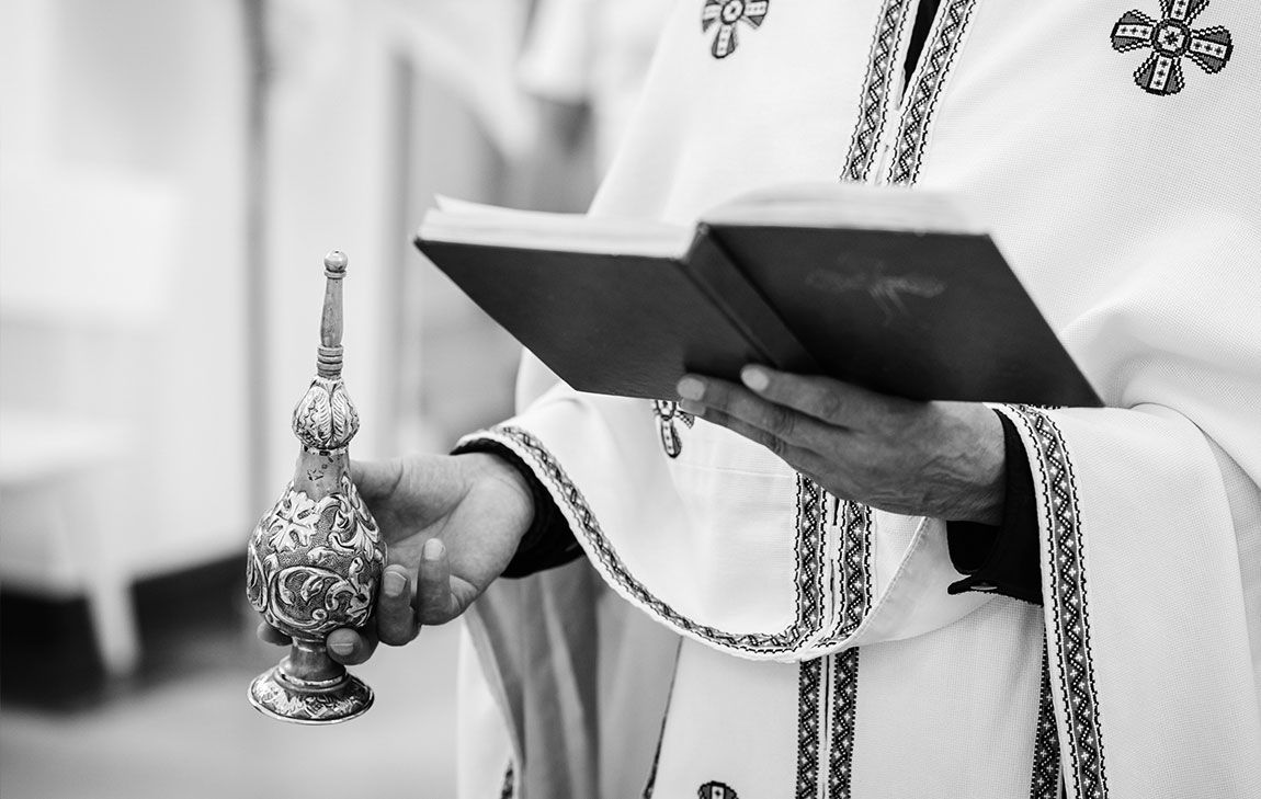Greek Orthodox priest presiding over a Trisagion funeral service