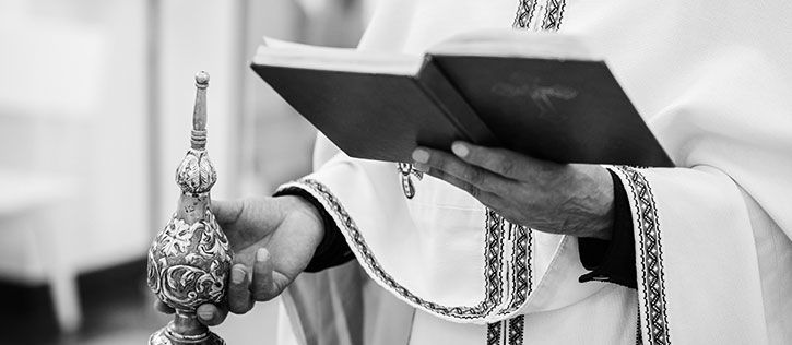 Greek Orthodox priest presiding over a Trisagion funeral service