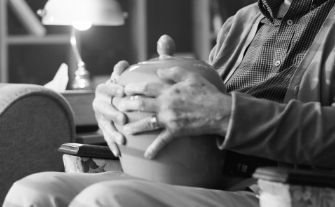Family member holding a cremation urn during a quiet moment of remembrance, reflecting the simplicity and dignity of direct cremation services.