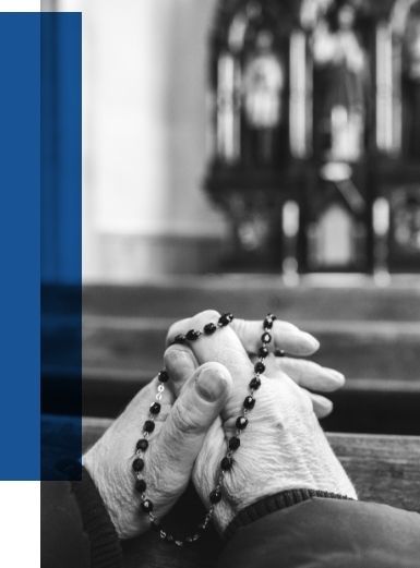 Mourner holding a rosary in prayer during a Vietnamese Catholic funeral Mass, reflecting faith, remembrance, and Catholic funeral traditions.