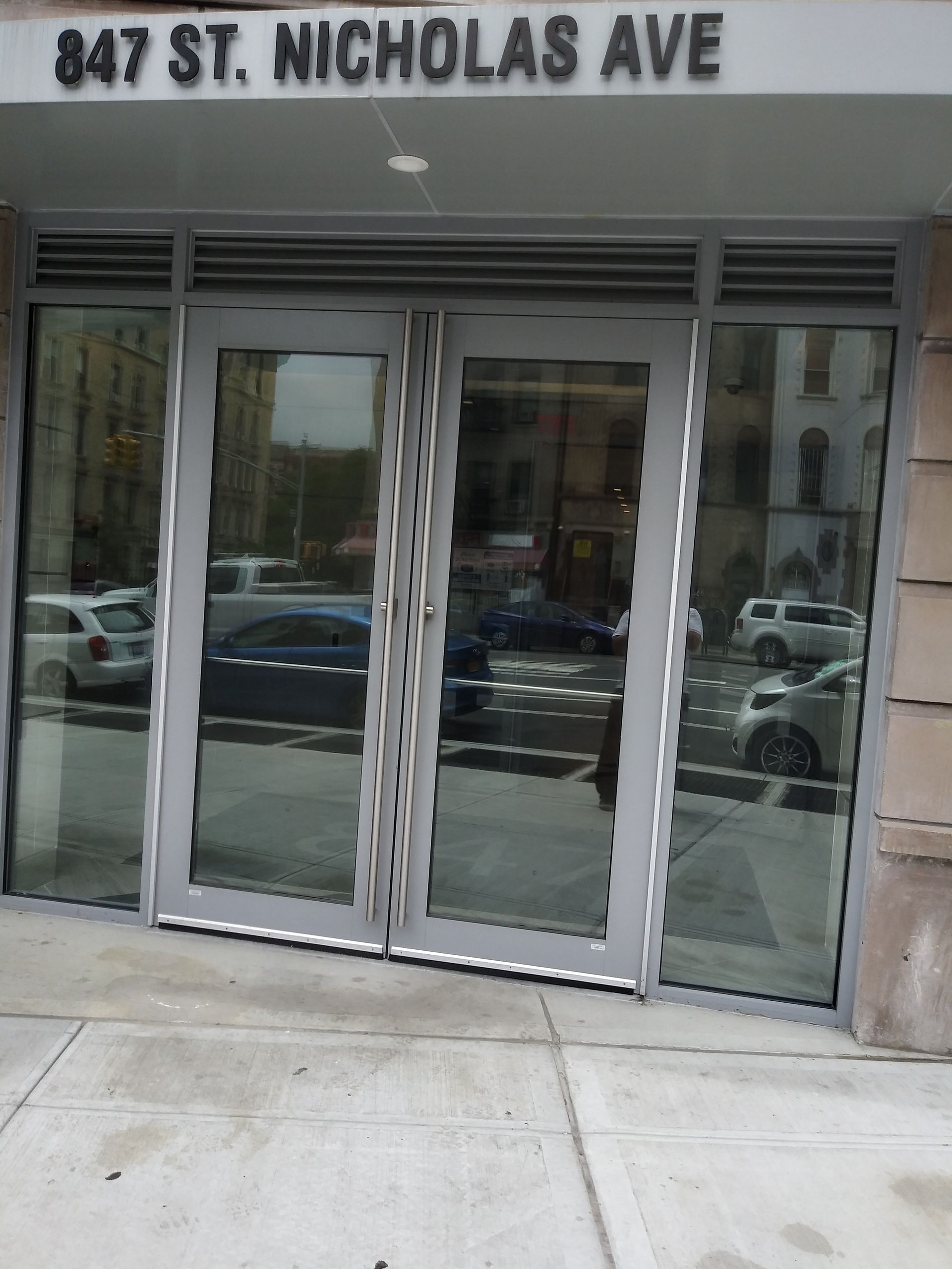 Glass storefront entrance at 847 St. Nicholas Ave with double doors and side windows