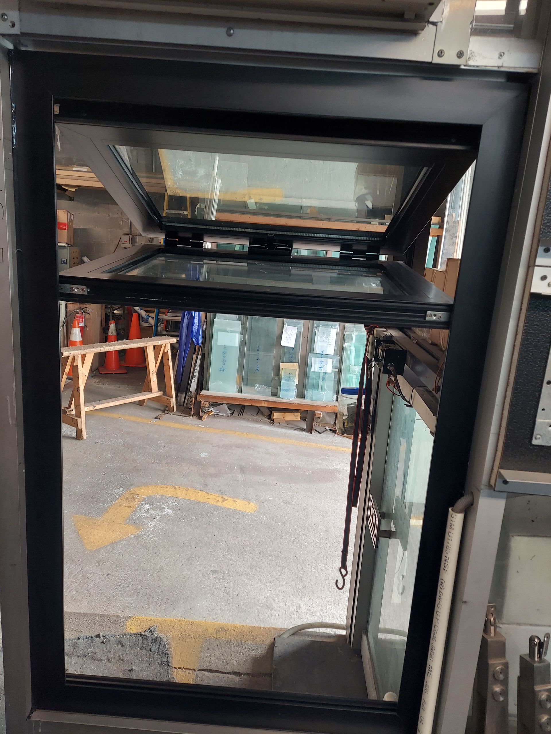 View from inside a bus lift looking out to a street and construction area through open doors.