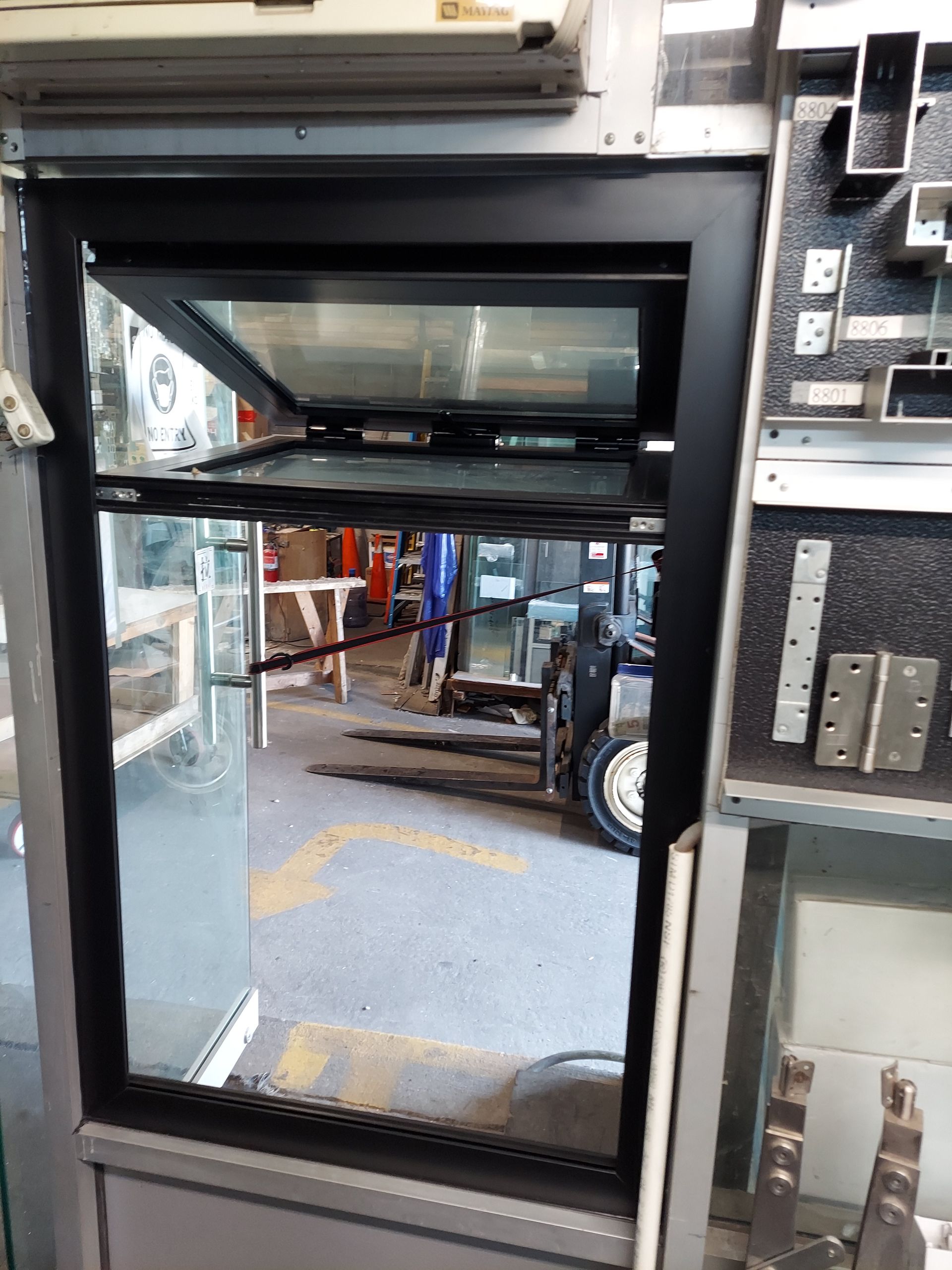 Open glass door from a vehicle interior, looking out to a street and parked truck.