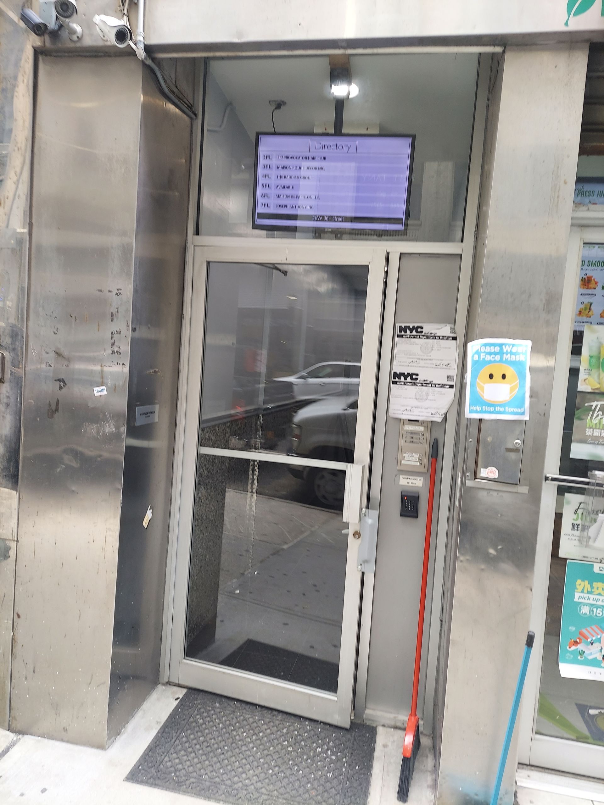 Elevator entrance with open door, digital display above, and stainless steel frame in a building lobby