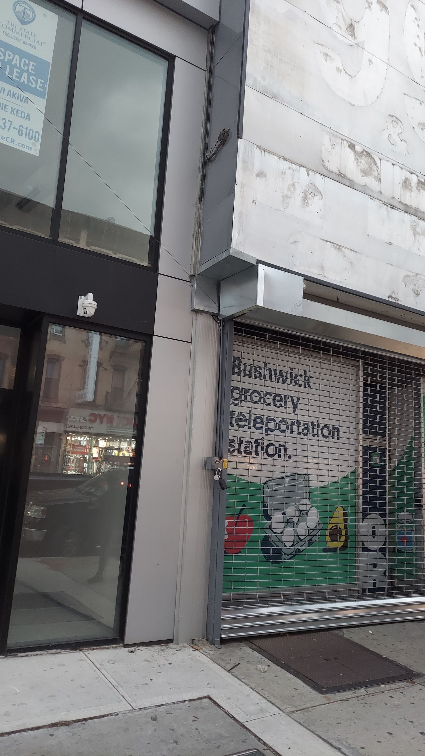 Storefront with a graffiti-covered metal shutter next to a glass door on a city sidewalk.