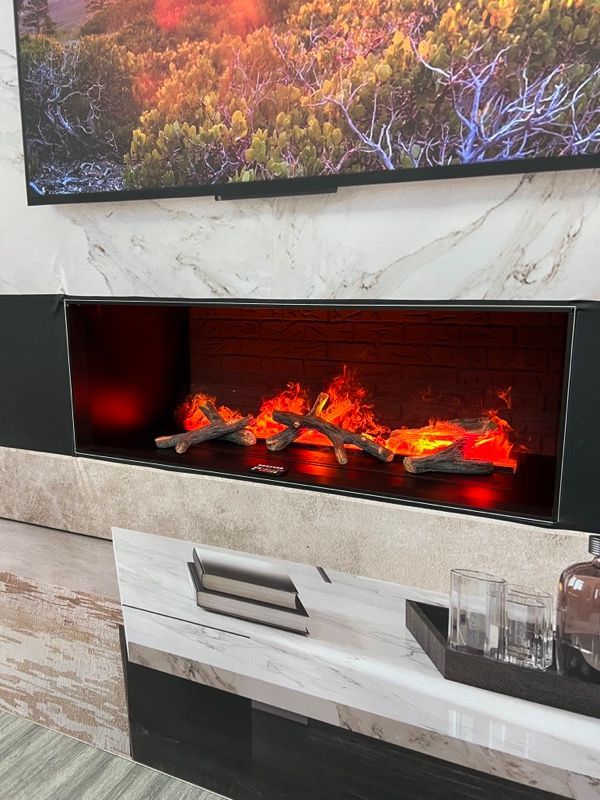 Modern wall-mounted electric fireplace with glowing logs beneath a mounted abstract artwork
