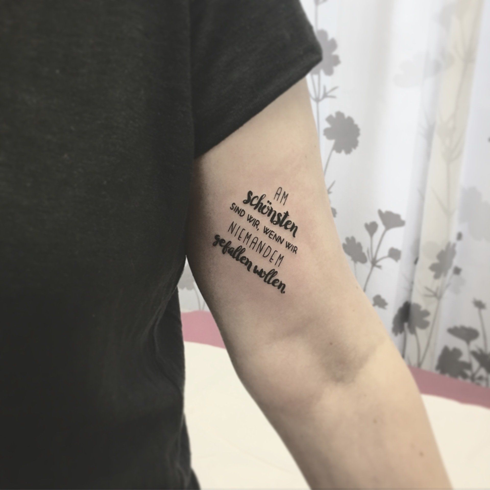 Tattoo of German text on an arm: 