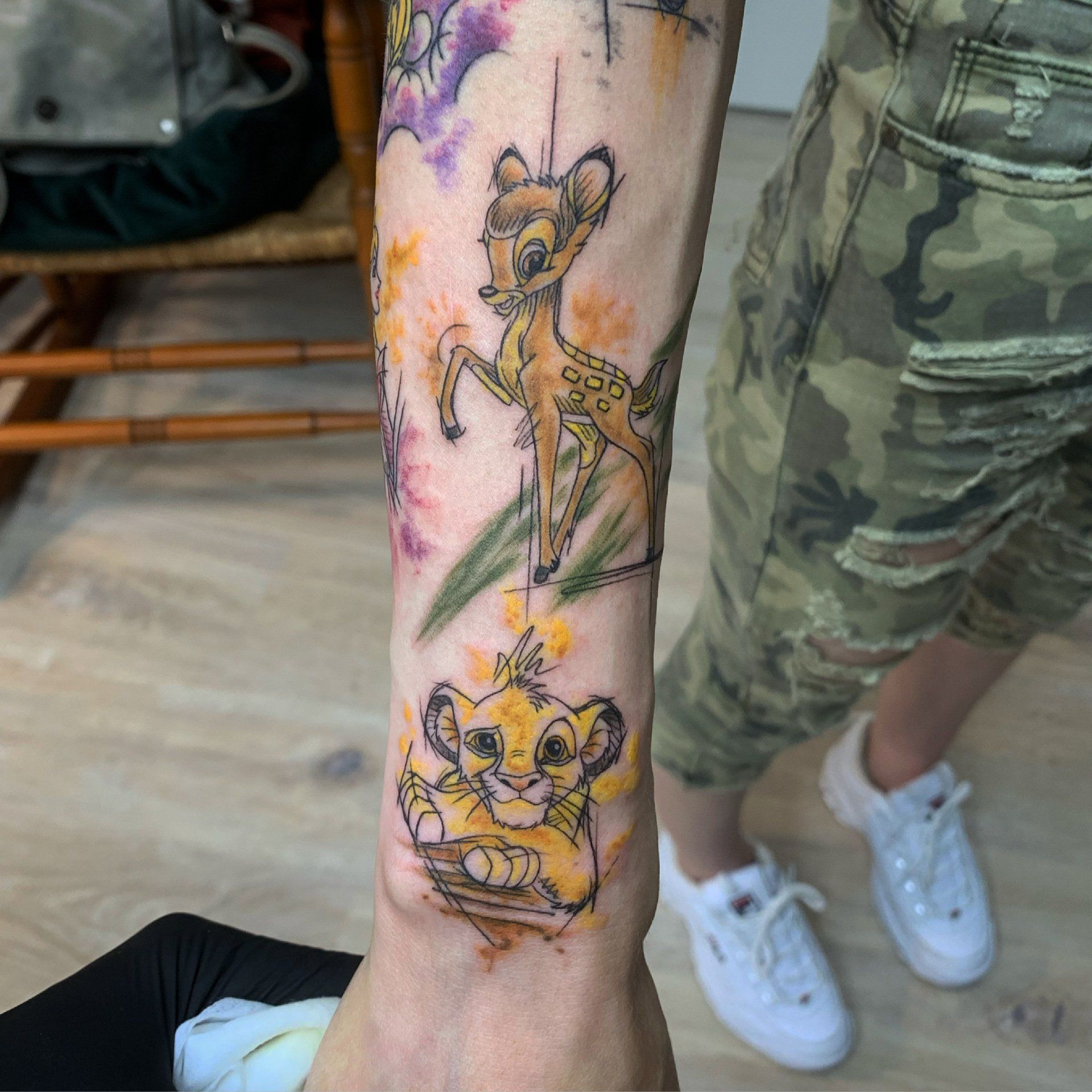 Armtattoo von Bambi und Simba mit Aquarellakzenten.