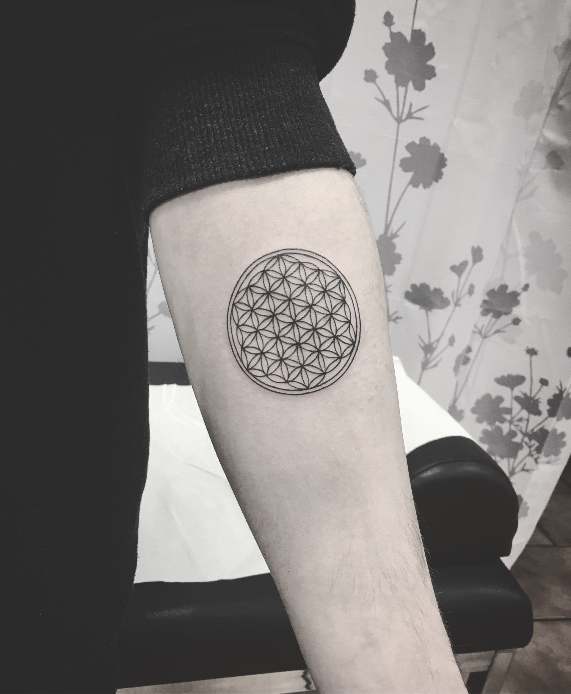 Schwarzes, geometrisches Tattoo der Blume des Lebens auf dem Unterarm.