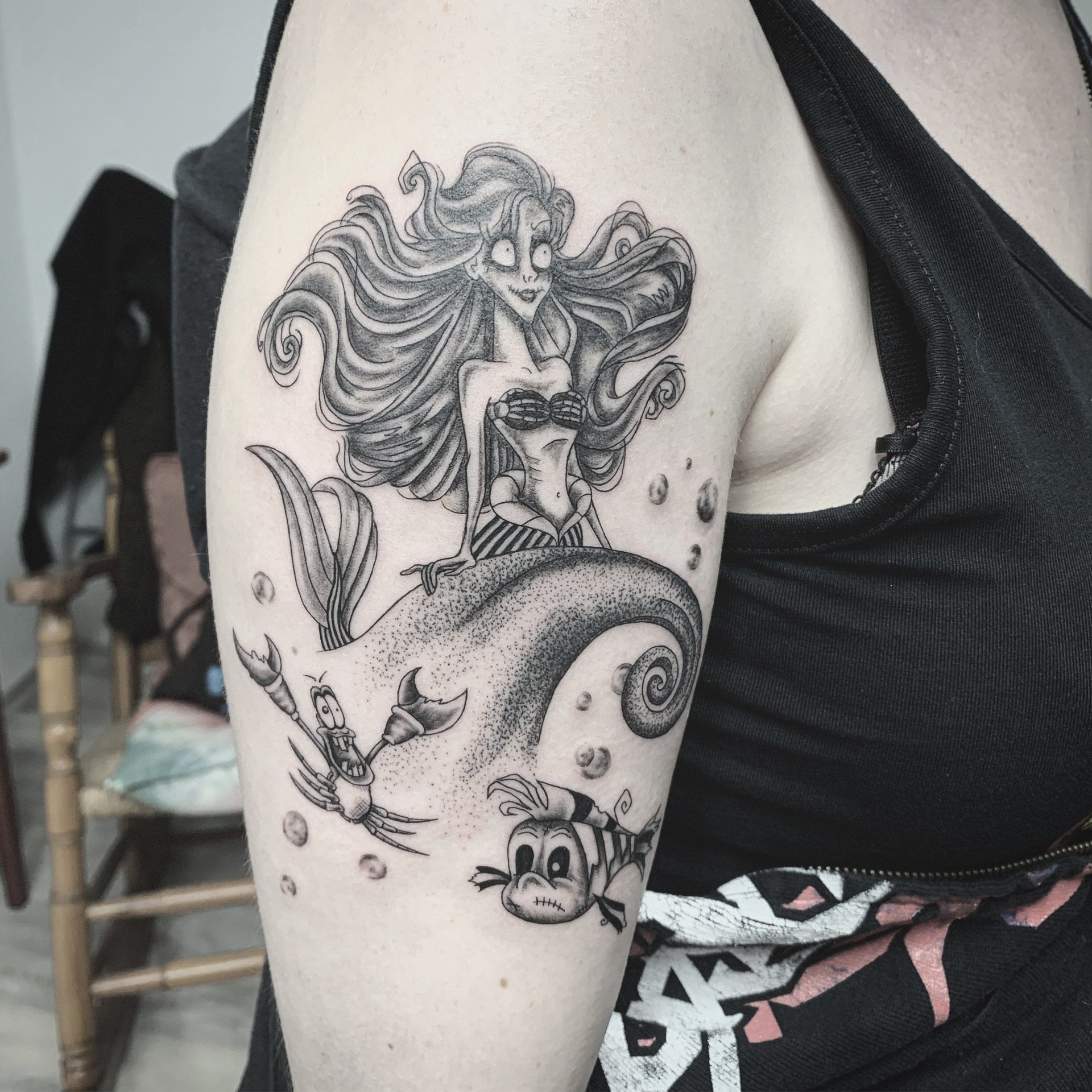 Schwarz-weißes Meerjungfrauen-Tattoo auf dem Arm; Ariel mit Fabius und Sebastian.