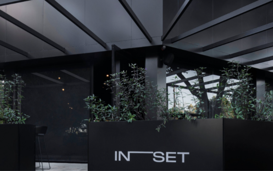 Modern office space with tables, chairs, and decorative wall.