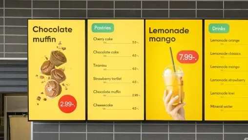 Digital menu board displaying food and drink options.
